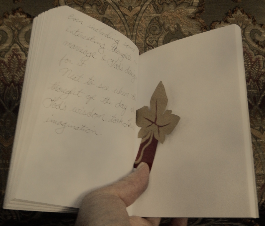 open journal with leaf bookmark